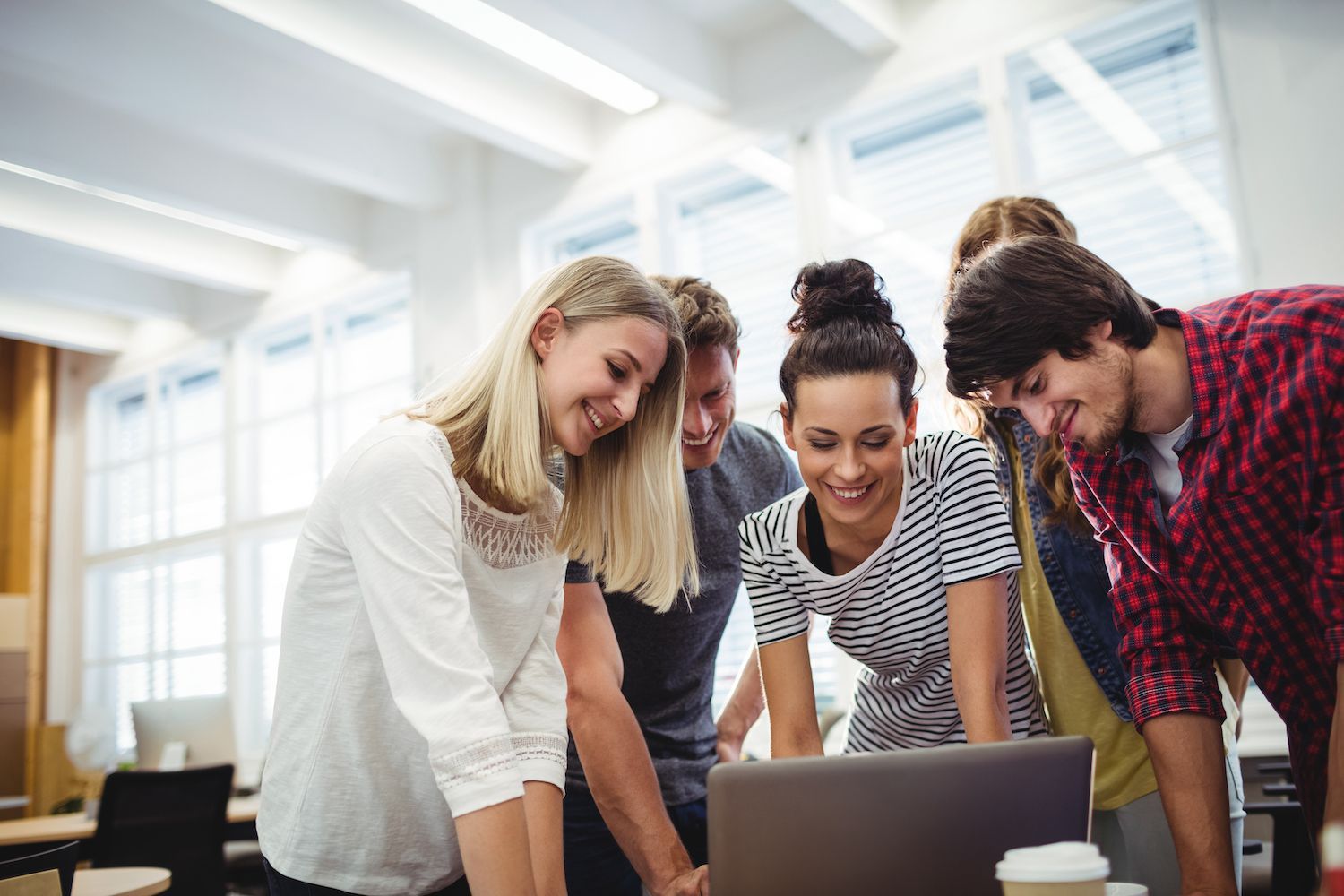 a woman  in a meeting with other co-workers discussing charts and graphs, representing market research.